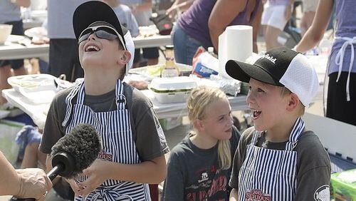 Ben Henricks, left, 8, and his younger brother, Graeme Henricks, both of Fenton, Mo., laugh at a question about where hamburgers come from during the Kids Que competition at the American Royal at Kansas Speedway. (David Eulitt/Kansas City Star/TNS)