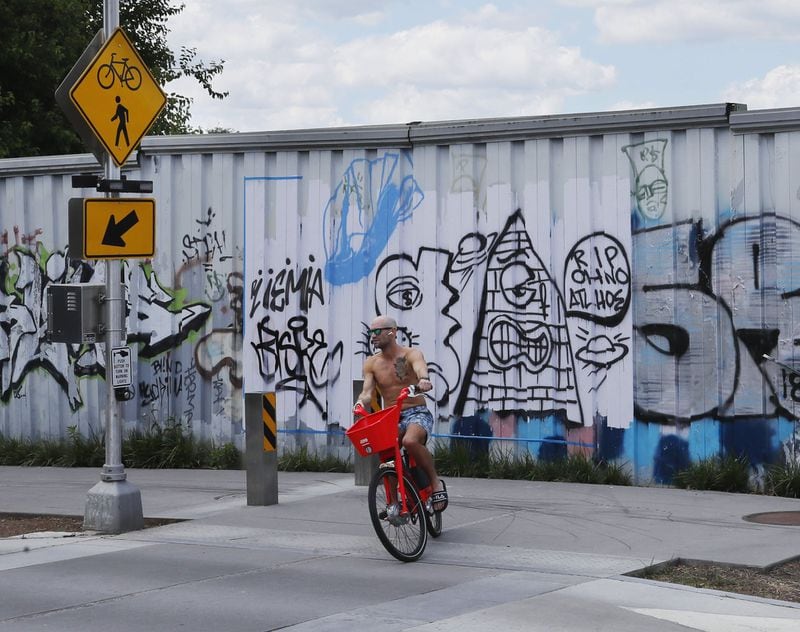May 6, 2019 - Atlanta - A bicycle rider turns south onto the Atlanta Beltline eastside trail in front of the graffiti filled fence that borders the CSX yard. CSX is shifting international freight operations out of a massive switching station known as Hulsey Yard that bisects the Atlanta Beltline’s eastside trail. The site, which stretches some 40 to 70 acres along DeKalb Avenue east of downtown Atlanta, could be a lucrative redevelopment site. Eliminating the rail yard — the east-west tracks would remain active — also could help advance transit along the Beltline and become one of the premiere development locations in the city. Bob Andres / bandres@ajc.com