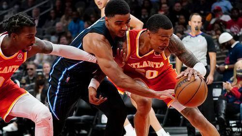 Orlando's Chuma Okeke battles John Collins of the Hawks while Delon Wright reaches in during the first half of Monday's game at State Farm Arena. (AP Photo/John Bazemore)