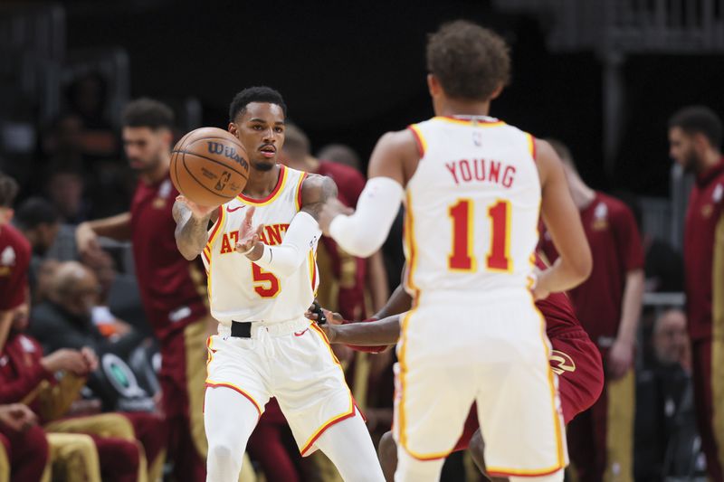 Atlanta Hawks guard Dejounte Murray (5) passes to guard Trae Young (11) during the first half against the Cleveland Cavaliers in a NBA preseason game at State Farm Arena, Tuesday, October 10, 2023, in Atlanta. (Jason Getz / Jason.Getz@ajc.com)