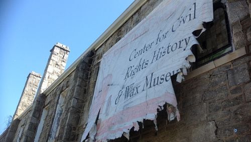 A tattered sign hangs delicately from the West Hunter church. The sign announced a civil rights museum that never came.