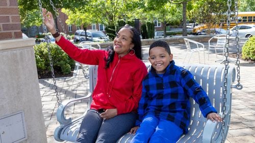 Immanuel Stephens swings with his mother Lisa at the Sandy Springs City Green Park. Immanuel , 7, participated in the Autism Transit Project for MARTA.  PHIL SKINNER FOR THE ATLANTA JOURNAL-CONSTITUTION