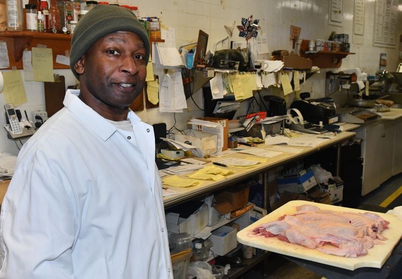 231120 Atlanta, Ga: Diamond Mardell, owner and operator of ShieldÕs Meat Market poses in his work area. Mardell says every one of those yellow slips of paper on the table behind him is an order. Mardell is a sole operator on all but his busiest days of the year, Mardell says, ÒitÕs a lot of work, but itÕs OK - because I know I can do the work of 3 peopleÓ. Photo for use in AJC Made In Georgia column by CW Cameron. The AJC visits ShieldÕs Meat Market, a seventy-six year old business started in downtown Decatur and now operating in the Emory Village business district, 1544 N.Decatur Road, Suite B, Atlanta, Ga. 30307. Owner and proprietor Diamond Mardell will be the guide for the tour. (CHRIS HUNT FOR THE ATLANTA JOURNAL-CONSTITUTION)
