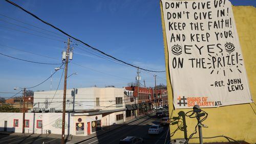 A quote from Congressman John Lewis is printed on a banner hanging on Edgewood Avenue in the Martin Luther King district, as part of the Signs of Solidarity effort. Artist: Catlanta; Photo: Brandon English