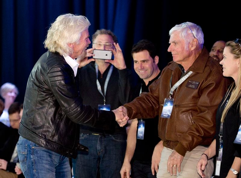 FILE - Sir Richard Branson, left, shakes hands with record breaking aviator Dick Rutan after Virgin Galactic's SpaceShipTwo space tourism rocket was unveiled, Friday, Feb. 19, 2016, in Mojave, Calif. Rutan, a decorated Vietnam War pilot, who along with copilot Jeana Yeager completed one of the greatest milestones in aviation history: the first round-the-world flight with no stops or refueling, died late Friday, May 3, 2024. He was 85. (AP Photo/Mark J. Terrill, File)
