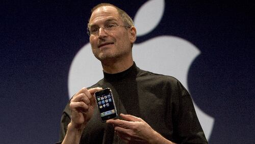 Apple CEO Steve Jobs holds up the new iPhone that was introduced at Macworld on January 9, 2007 in San Francisco, California. The new iPhone will combine a mobile phone, a widescreen iPod with touch controls and a internet communications device with the ability to use email, web browsing, maps and searching. The iPhone will start shipping in the US in June 2007.