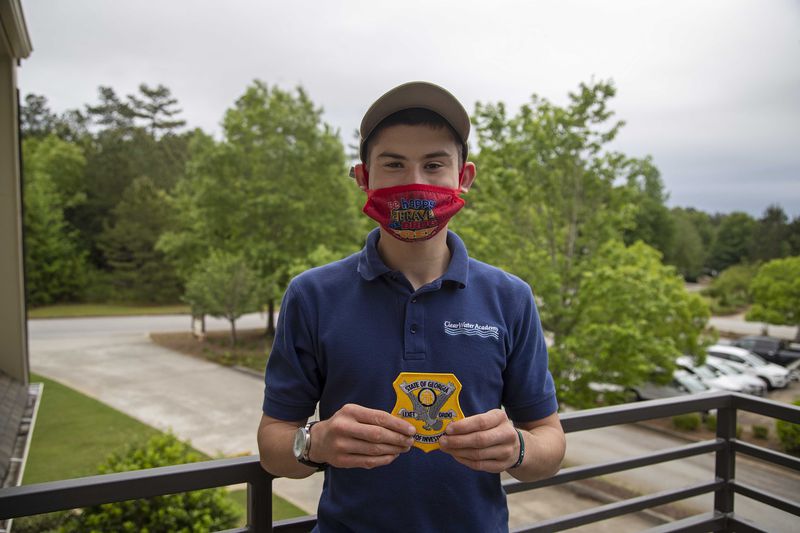 Asher Williams shows off a Georgia Bureau of Investigation patch he received from GBI Crime Scene Specialist Daniella Stuart at ClearWater Academy in Tyrone on Tuesday, May 4, 2021. (Alyssa Pointer / Alyssa.Pointer@ajc.com)
