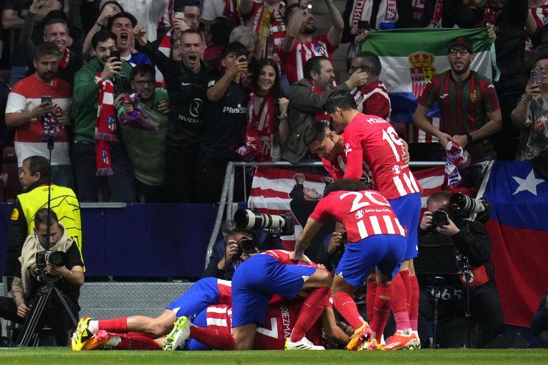 Atletico Madrid players celebrate after Atletico Madrid's Samuel Lino scored his side's second goal during the Champions League quarterfinal soccer match between Atletico Madrid and Borussia Dortmund at the Metropolitano stadium in Madrid, Spain, Wednesday, April 10, 2024. (AP Photo/Manu Fernandez)