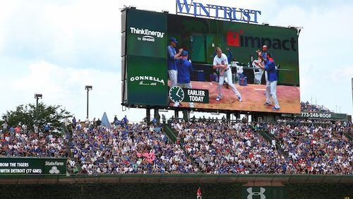 A replay of Chicago Cubs players in the bullpen dancing is shown on the video board after catcher Alex Avila (13) hits a first inning, two-run home run against the Washington Nationals on Saturday, Aug. 5, 2017 at Wrigley Field in Chicago, Ill. (John J. Kim/Chicago Tribune/TNS)