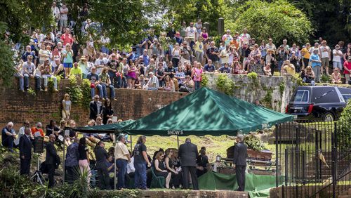Family, friends and fans attend Gregg Allman's burial at Rose Hill Cemetery, Saturday, June 3, 2017, in Macon, Ga. The family hopes to modify the area and remove the fence separating Gregg from his brother Duane and bandmate Berry Oakley. (AP Photo/Branden Camp)