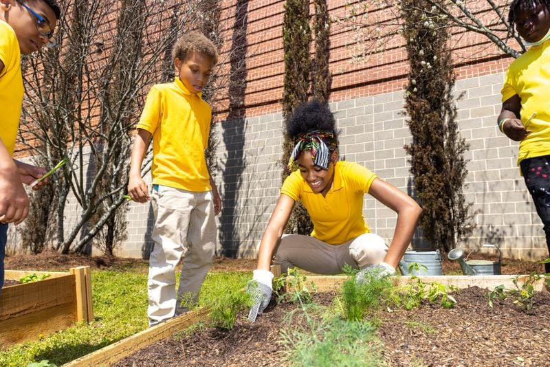 Students garden in a new community garden at Jean Childs Young Middle School in Atlanta on Thursday, March 30, 2023. Hip-hop group Earthgang helped sponsor the project. (Arvin Temkar / arvin.temkar@ajc.com)