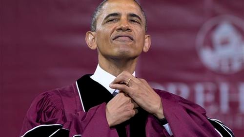 President Barack Obama straightens his tie before he receives an honorary doctorate of laws degree during the Morehouse College 129th Commencement ceremony on May 19, 2013, in Atlanta.