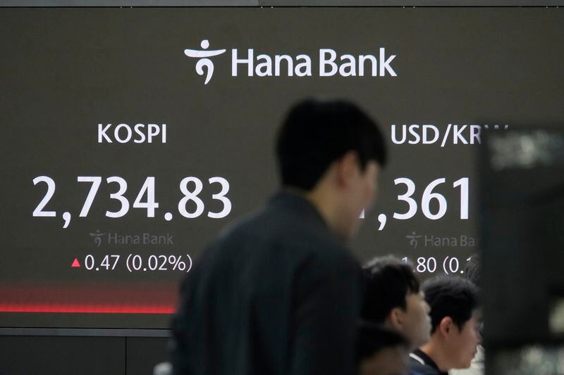 Currency traders work near the screen showing the Korea Composite Stock Price Index (KOSPI), left, and the foreign exchange rate between U.S. dollar and South Korean won at the foreign exchange dealing room of the KEB Hana Bank headquarters in Seoul, South Korea, Wednesday, May 8, 2024. (AP Photo/Ahn Young-joon)