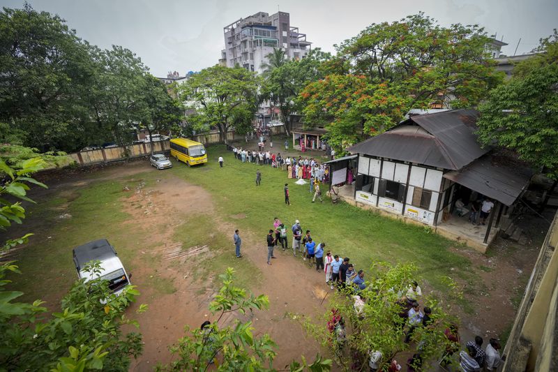People stand in queue to cast their votes in a polling station during the third phase of general election in Guwahati, India, Tuesday, May 7, 2024. (AP Photo/Anupam Nath)