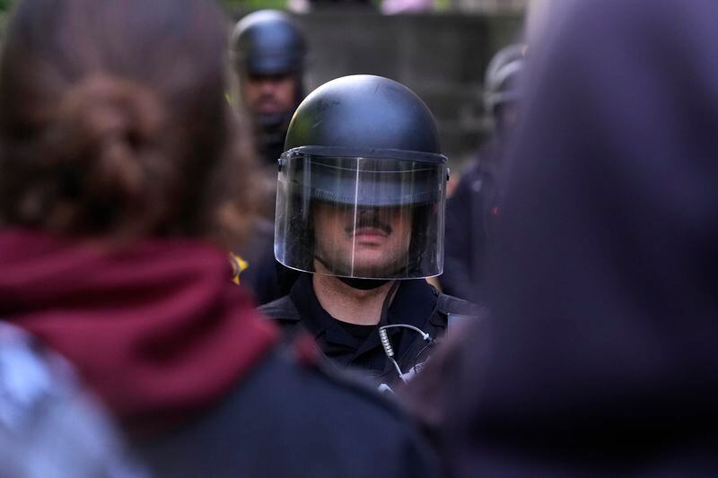A police officer stands guard blocking pro-Palestinian protesters from returning to their encampment as the encampment is dismantled at the University of Chicago, Tuesday, May 7, 2024. (AP Photo/Charles Rex Arbogast)