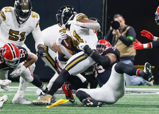 Atlanta Falcons defensive tackle Ta'Quon Graham (95) stops New Orleans Saints running back Alvin Kamara (41) for no gain during the second half of an NFL football game in Atlanta on Sunday, Nov. 26, 2023.   (Bob Andres for the Atlanta Journal Constitution)
