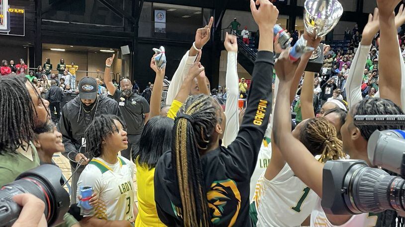 Griffin players hoist the championship trophy after defeating Baldwin 51-47 in the Class 4A girls basketball final at the Macon Coliseum on March 8, 2023.