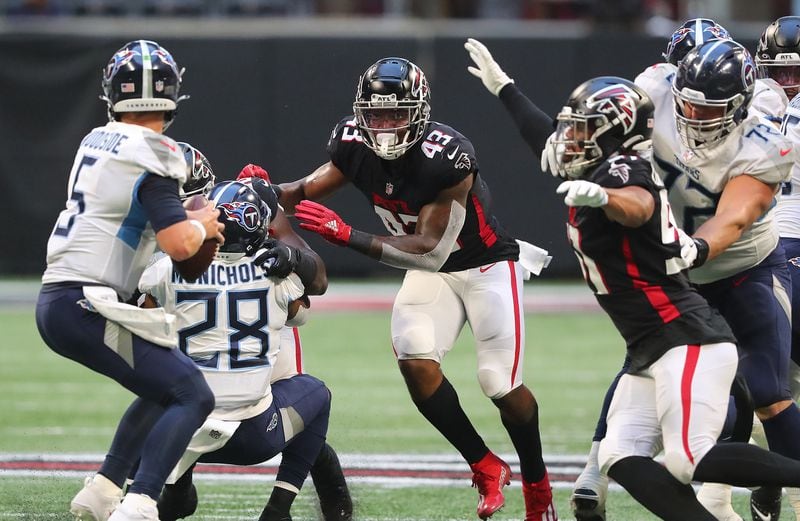 Falcons defenders Mykal Walker (center) and Jacob Tuioti-Mariner bring the pressure on a sack of Tennessee Titans quarterback Logan Woodside during the first half of exhibition game Friday, Aug. 13, 2021, at Mercedes-Benz Stadium in Atlanta. (Curtis Compton / Curtis.Compton@ajc.com)