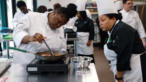 Zanaya Pullum stirs a sauce as Chef Mimi Bates, program director at the Navigate Foundation looks on during a guided cooking lesson on Tuesday, May 7, 2024. Through the program, students from Atlanta area schools get hands-on training in the field and culinary internships. (Natrice Miller/ AJC)