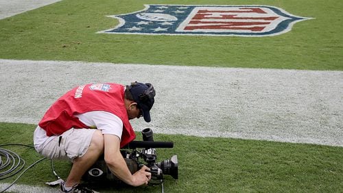 A camera man films the Atlanta Falcons in warm up before playing against the Houston Texans Aug. 16, 2014 in Houston, Texas.