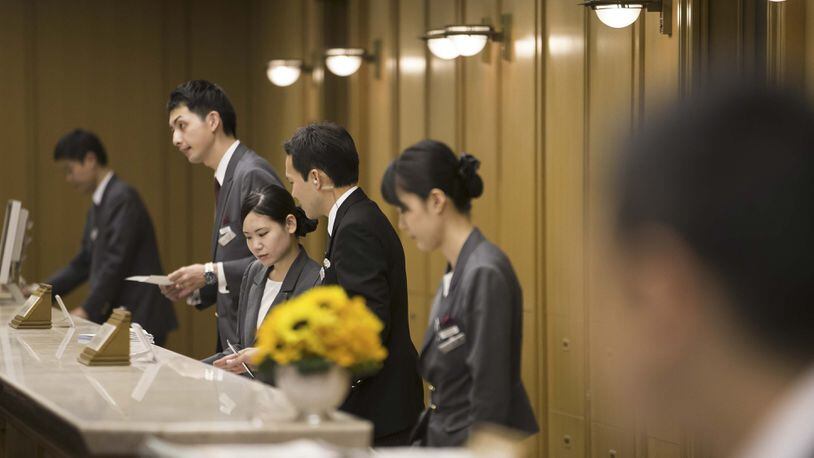 Employees at the reception area at the lobby of the Imperial Hotel in Tokyo on Aug. 19, 2016. Bloomberg photo by Tomohiro Ohsumi.