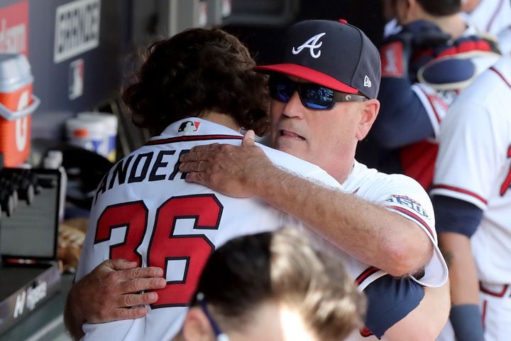 October 11, 2021 Atlanta: Atlanta Braves manager Brian Snitker, facing, hugs starting pitcher Ian Anderson (36) after Anderson recorded five shutout innings against the Milwaukee Brewers in Game 3 of the NLDS on Monday, October, 11, 2021, in Atlanta. Curtis Compton / Curtis.Compton@ajc.com