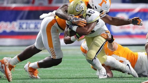 Georgia Tech quarterback TaQuon Marshall picks up short yardage as he is tackled by Tennessee linebacker Daniel Bituli during the first quarter in a NCAA college football game on Monday, September 4, 2017, in Atlanta.    Curtis Compton/ccompton@ajc.com