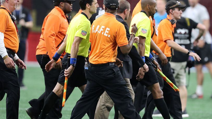 Security guards escort the game officials off the field after a heated match between Atlanta United and Sporting Kansas City in a MLS soccer match on Wednesday, May 9, 2018, in Atlanta.  Curtis Compton/ccompton@ajc.com