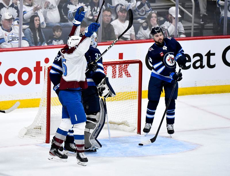 Winnipeg Jets' Neal Poink (4) takes the puck out of the net after a goal by Colorado Avalanche's Artturi Lehkonen during the second period in Game 5 of an NHL hockey Stanley Cup first-round playoff series in Winnipeg, Manitoba, Tuesday, April 30, 2024. (Fred Greenslade/The Canadian Press via AP)