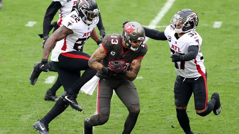 Tampa Bay Buccaneers wide receiver Mike Evans (13) splits between Atlanta Falcons strong safety Keanu Neal (22) and free safety Ricardo Allen (37) after a catch during the first half Sunday, Jan. 3, 2021, in Tampa, Fla. The catch put Evans over the 1,000 yard total for the season. (Mark LoMoglio/AP)