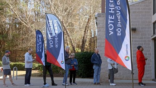 Gwinnett County “Vote Here” signs are shown as voters lineup outside of the Pinckneyville Park Community Recreation Center for early voting for the Georgia runoff for U.S. Senate in November. The state is preparing to cancel over 191,000 inactive voter registrations, but voters can still take steps to save their registrations. Jason Getz / Jason.Getz@ajc.com)