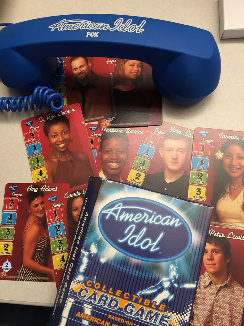 A couple of pieces of swag I managed to still have on my desk after all these years: a season 3 collector card game and a season 11 (ish) phone headset. CREDIT: Rodney Ho/rho@ajc.com