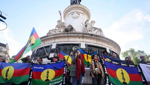Demonstrators hold Kanak and Socialist National Liberation Front (FLNKS) flags during a gathering in Paris, Thursday May.16, 2024. Violence raged across New Caledonia for the third consecutive day Thursday, hours after France imposed a state of emergency in the French Pacific territory, boosting security forces' powers to quell unrest in the archipelago that has long sought independence. (AP Photo/Thomas Padilla)