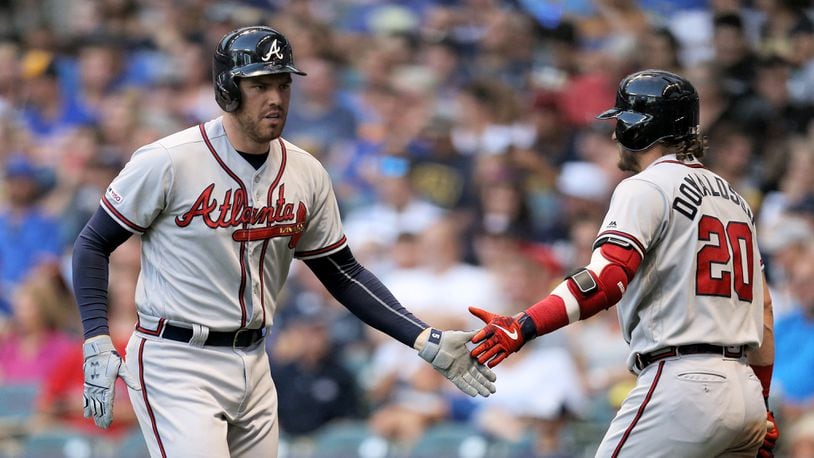 Braves' Freddie Freeman and Josh Donaldson celebrate after Freeman hit a home run in the fourth inning July 15, 2019, against the Brewers at Miller Park in Milwaukee.