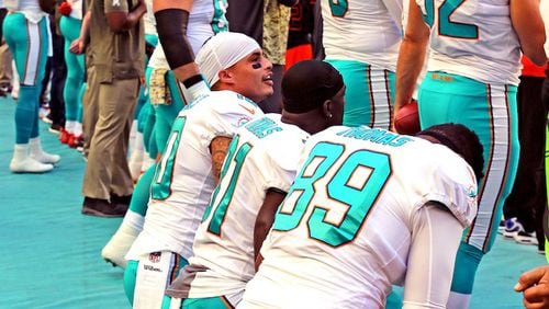 Miami Dolphins Kenny Stills (10), Michael Thomas (31), and Julius Thomas kneel during the national anthem as they prepare to play the Tampa Bay Buccaneers on Sunday, Nov. 19, 2017 at Hard Rock Stadium in Miami Gardens, Fla. (Charles Trainor Jr./Miami Herald/TNS)
