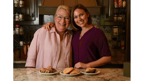 Ellen Wilson and her daughter Leah Parris, owner of Flour + Time vegan bakery, pose in the kitchen of Wilson's Forsyth home. The mother and daughter show some of Parris' favorite family recipes that have been turned into vegan treats: (from left) Miss Ellen’s Lunchbox Bars, Strawberry Turnovers and Mrs. Fox’s Shoofly Pie. (Styling by Leah Parris / Chris Hunt for the AJC)