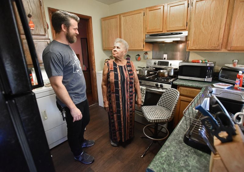 Justin Schaeffer and Annie Williams talk in her kitchen where a neighborhood group, Kirkwood Cares, replaced the floor. (Hyosub Shin / Hyosub.Shin@ajc.com)