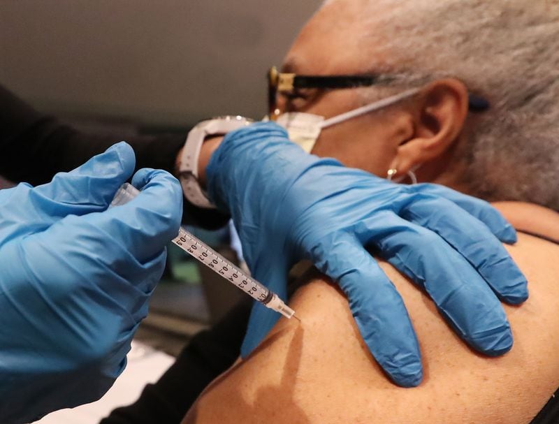 Fulton County Board of Health registered nurse Greer Pearson gives Brenda Malik a Pfizer vaccine at the mass vaccination site at Mercedes-Benz Stadium on Wednesday. (Curtis Compton / Curtis.Compton@ajc.com)