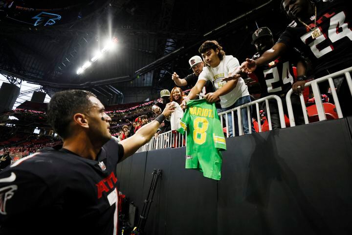 Falcons quarterback Marcus Mariota hands his towel to a fan as he leaves the field Sunday in Atlanta. The Falcons defeated the Panthers 37-34 in overtime. (Miguel Martinez / miguel.martinezjimenez@ajc.com)