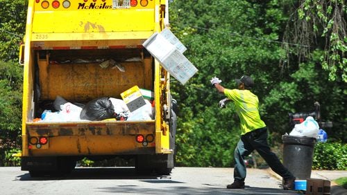 DeKalb County sanitation worker Larry Wyatt tosses trash into a truck in this 2012 file photo.