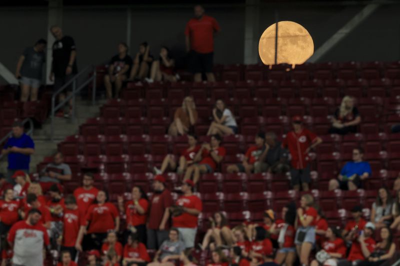 A view of the moon is seen through the outfield scoreboard during the ninth inning of a baseball between the Atlanta Braves and the Cincinnati Reds, Thursday, June 24, 2021. The Reds won 5-3. (AP Photo/Aaron Doster)