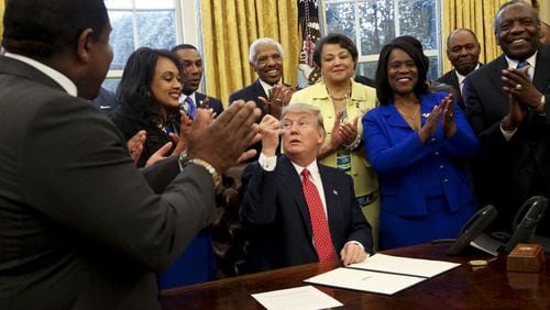 President Donald Trump gives a pen after signing the HBCU Executive Order to support Black Colleges and Universities in the Oval Office of the White House in February 2017. (Photo by Aude Guerrucci-Pool/Getty Images)
