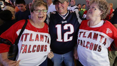 Falcons fans Sharon Vickery (left) and Diane Page (right), both from Canton, have some good-natured fun with Patriots fan Jesssalyn DiManno in Houston. They were all taking in the pro football interactive theme park the NFL Experience. Curtis Compton/ccompton@ajc.com