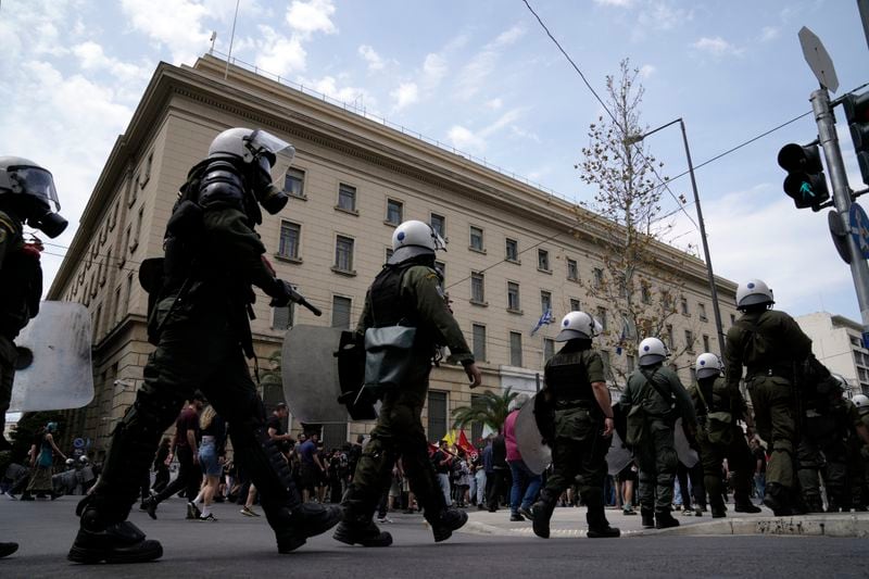 Riot police flank protesters during a rally in Athens, Greece, Wednesday, April 17, 2024. A 24-hour strike called by Greece's largest labor union have halted ferries and public transport services in the Greek capital and other cities, to press for a return of collective bargaining rights axed more than a decade ago during a severe financial crisis. (AP Photo/Thanassis Stavrakis)