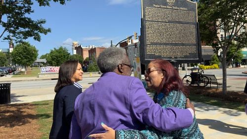 Muriel Jackson, right, embraces Alex Habersham during Monday's unveiling of one of three new Black history markers being installed in downtown Macon, Georgia on Monday, April 22, 2024. Jackson, head of the Genealogical and Historical Room and Middle Georgia Archives at the Washington Memorial Library, wrote the text for the markers.