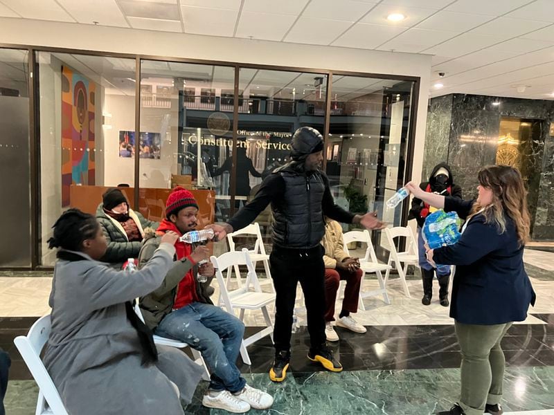 Caitlin King, a community affairs manager for the city of Atlanta, handed out water to unhoused people Tuesday outside the mayor's office of constituent services in City Hall.