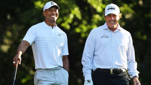 Tiger Woods and Phil Mickelson share a laugh on the 11th tee box while playing a practice round together for the Masters at Augusta National Golf Club on Tuesday, April 3, 2018, in Augusta.  Curtis Compton/ccompton@ajc.com