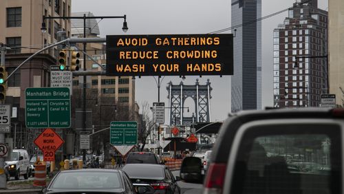 In this March 19, photo, a flashing sign urges New Yorkers to avoid gatherings, reduce crowding and to wash hands.  A South Georgia teacher fears that message has not yet been taken seriously in her community, and that puts her husband at risk due to pre-existing health conditions.