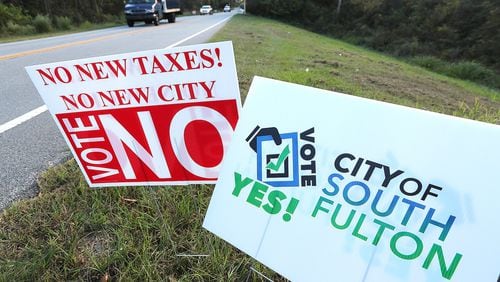Traffic on Enon Road passes by signs for and against forming the City of South Fulton. Curtis Compton /ccompton@ajc.com