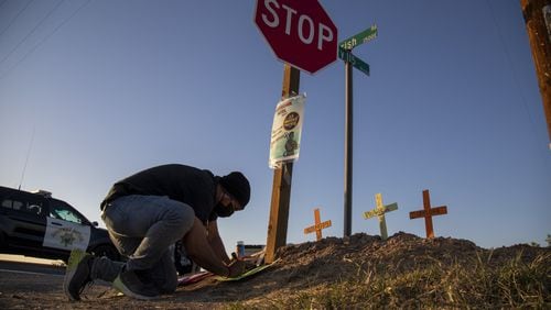 Hugo Chavez, an activist with the Coalition for Human Immigration Rights, places crosses at the scene where an SUV carrying 25 people collided with a semi-truck killing 13 on Highway 115 near the Mexican border on Tuesday in Holtville, California. The passengers in the SUV ranged in age form 15-53. (Gina Ferazzi/Los Angeles Times/TNS)